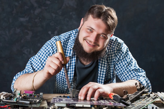 Repairman fixing problem with soldering tool. Engineer repairs computer components with soldering iron.