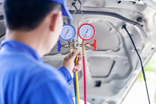 Photo repairman holding monitor tool to check and fixed car air conditioner system technician check car air conditioning system refrigerant recharge air conditioning repair