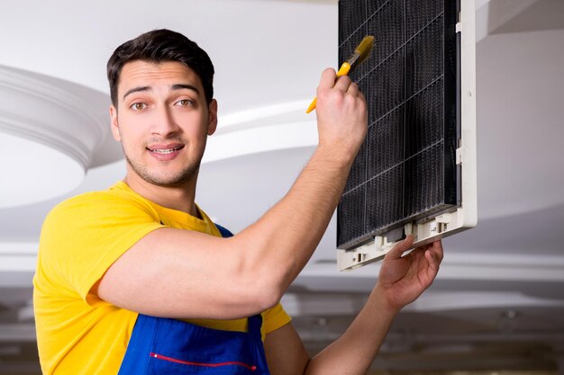 Repairman repairing ceiling air conditioning unit