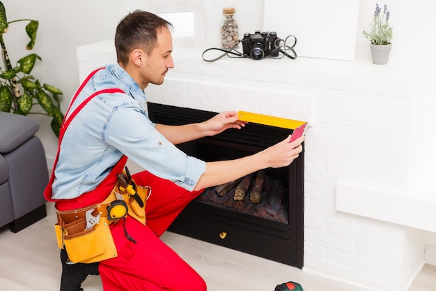 repairman repairs and installs a fireplace in the apartment