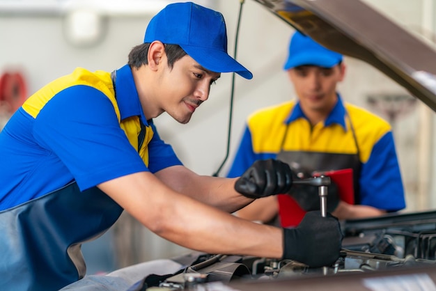 repairman and technician in car garage service in blue uniform standup smile with tooling on hand