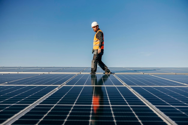 A repairman walking on the rooftop and looking for solar panel to fix