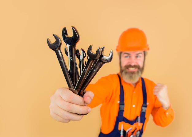 Repairment tools worker holds wrenches building industry technology spanner bearded builder builder