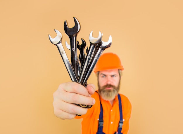 Repairment tools worker holds wrenches business building industry technology spanner bearded builder