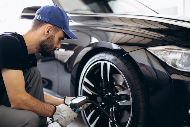 Reparateur bij autoservice die wieldruk controleert