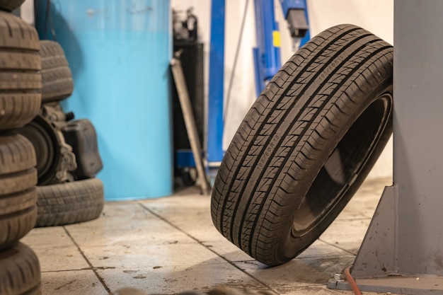 Reparatie en controleer auto in reparatiewerkplaats. Een ervaren technicus repareert het defecte deel van de auto. Ik wissel banden