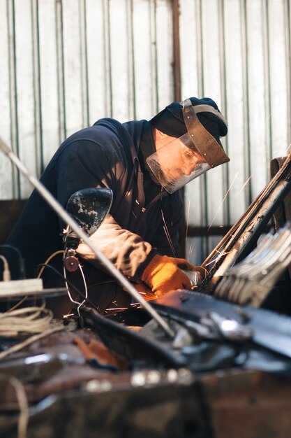 Reparatie oude beschadigde auto door man in werkplaats