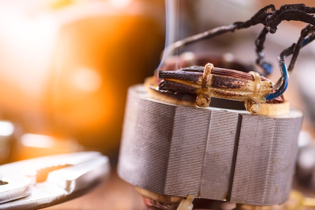 Reparatie van elektrisch gereedschap. Details van elektrisch apparaat en reparatie tools op een houten tafel in een reparatiewerkplaats.