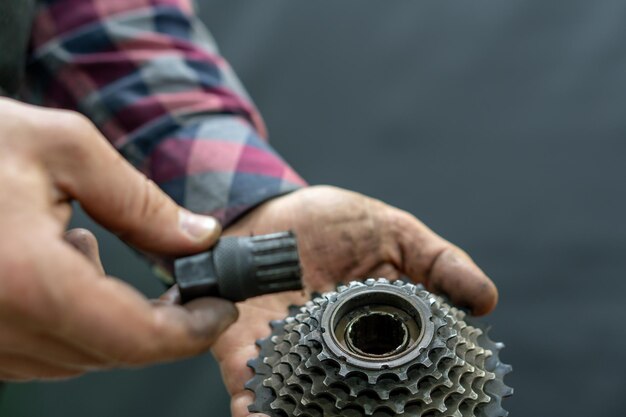 Foto reparatie van mountainbikes en racefietsen mechanische handen en een cassetteclose-up op een zwarte achtergrond vervanging van versleten reserveonderdelen