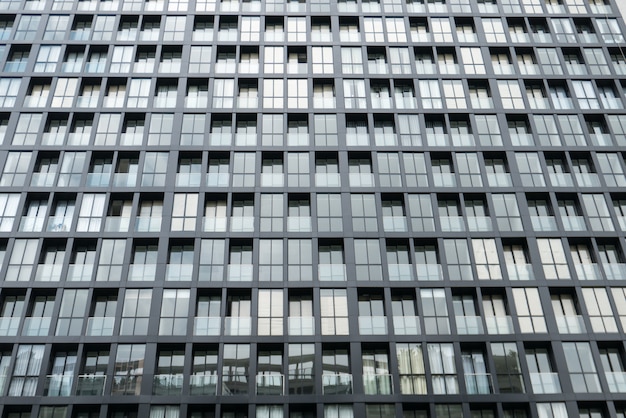 Repeatition window facade on high rise modern building in sunny day in downtown