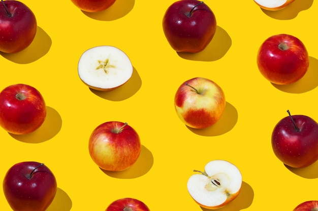 Photo repetitive pattern of whole and sliced apples on yellow background healthy eaten concept