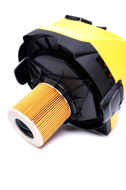 Replaceable air filter on the cover of a yellow construction vacuum cleaner isolate on a white background