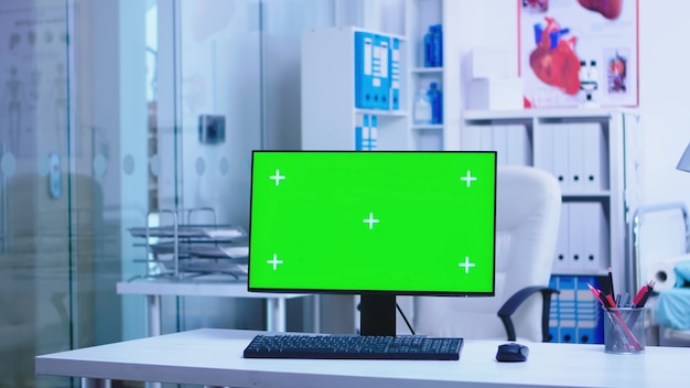 Replaceable computer display in hospital and doctor arriving in health clinic. Desktop with blank and copy space available on display of medicine specialist in clinic cabinet.