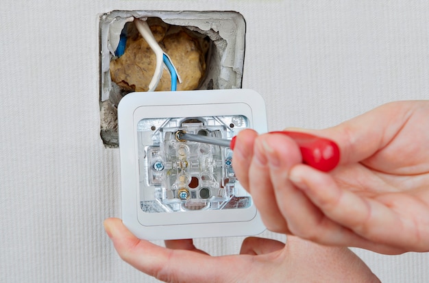 Replacing or repairing indoor light switch electrician installs\
appliance and connects electrical wires to box