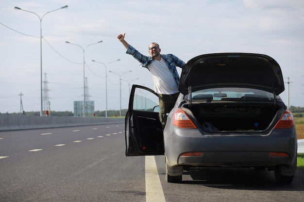 道路上の車のホイールを交換します。傍観者としてタイヤの仕事をしている男性。