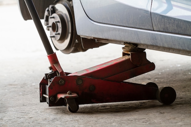 Replacing wheels on a car, jack holds the body in raised position.