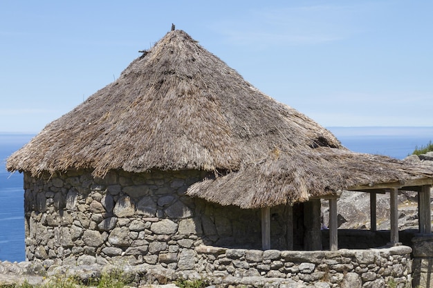 Photo replica of celtic huts at the castro archaeological site with ruins in santa tecla, galicia, spain