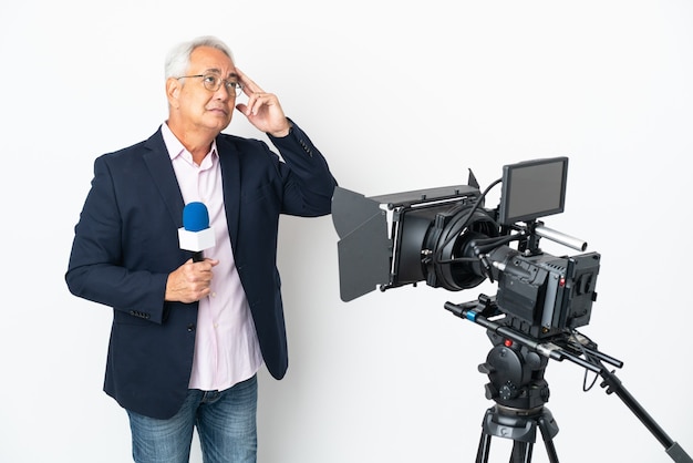 Репортер Среднего возраста бразильский мужчина держит микрофон и сообщает новости изолированно, сомневаясь и думая
