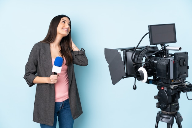 Reporter woman holding a microphone and reporting news on blue thinking an idea