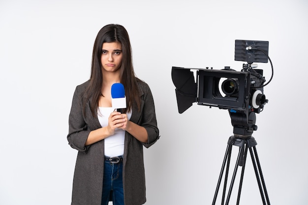 Reporter woman holding a microphone and reporting news over isolated white pleading