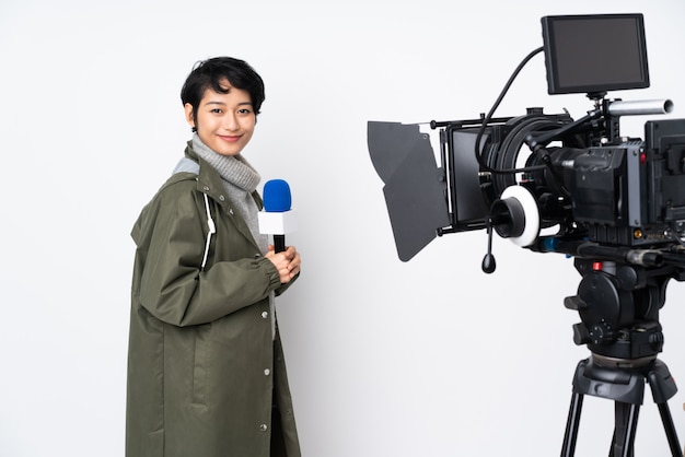 Reporter woman holding a microphone and reporting news with arms crossed and looking forward