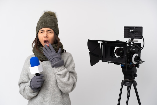 Reporter woman holding a microphone and reporting news yawning