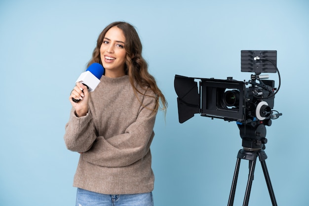 Reporter young woman holding a microphone and reporting news