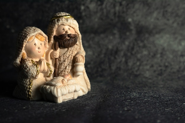 Representation of a Christmas nativity scene with the small figures of baby Jesus, Mary and Joseph on a rock background.