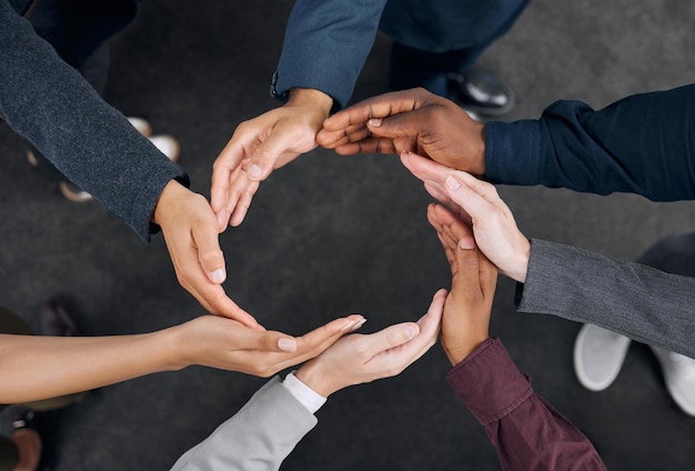 A representation of unity Shot of a group of businesspeople with their hands joined together to form a circle