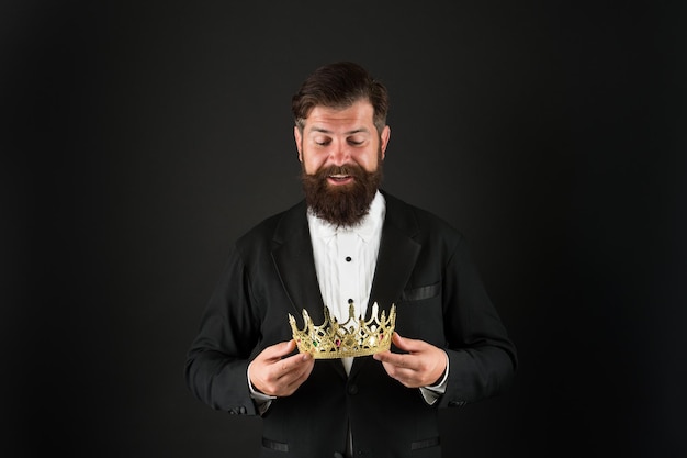 Reputation and status now come and make it worth crown in hands\
handsome man give crown black background getting reward crowning\
glory glory and ambitions king crown royal coronation symbol