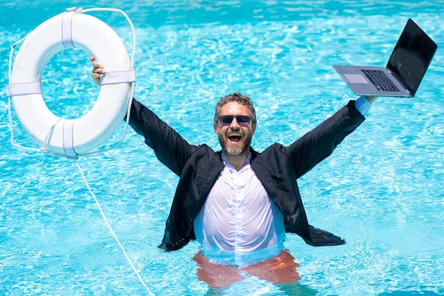 Rescue business business man in suit hold laptop and rescue lifebuoy in swim pool rescue swimming