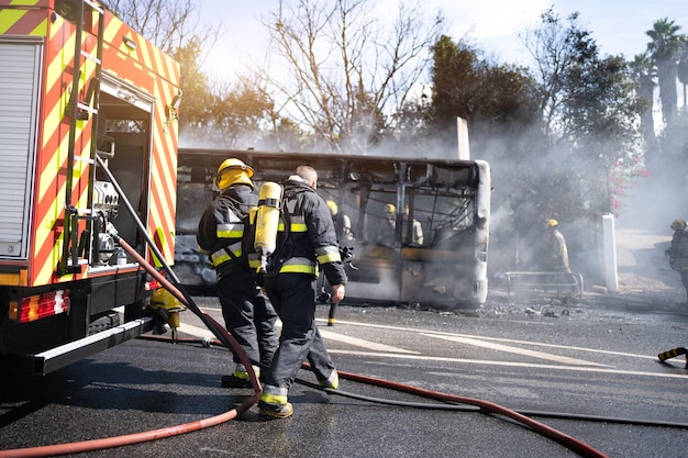 Photo rescue team of firefighters arrive on the car crash