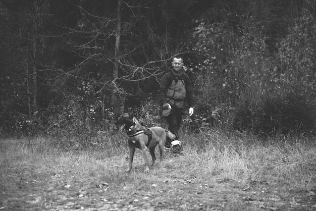 Rescuer and dog inspecting woods searching missing person