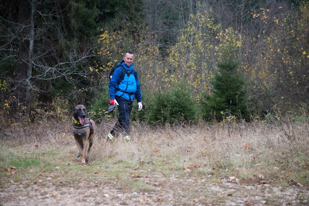 Rescuer and dog inspecting woods searching missing person