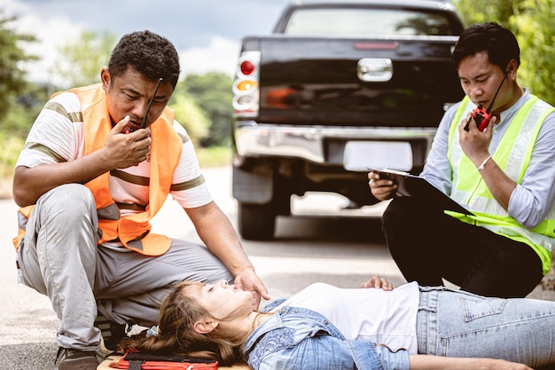 Photo rescure team radio calling help support women victim hit by car at roadside accident scene