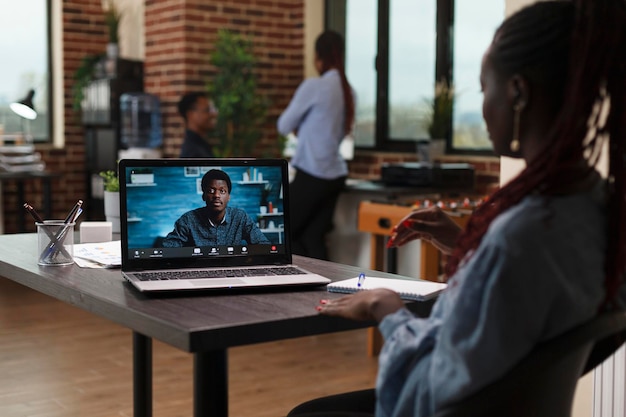 Photo research and development company team leader in videocall remote conference with ceo. marketing agency office worker talking with superior on digital video meeting while in office workspace.