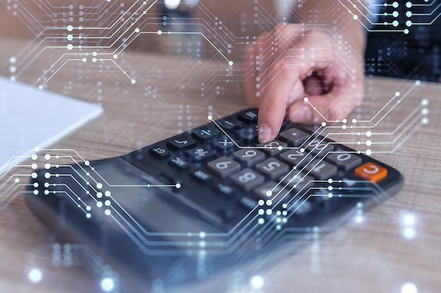 A research and development specialist computing the data to\
create a new approach to develop high tech business technological\
icons over the desk with calculator woman hand