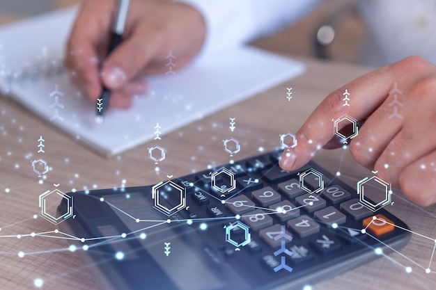 A research and development specialist computing the data to\
create a new approach to develop high tech business technological\
icons over the desk with calculator