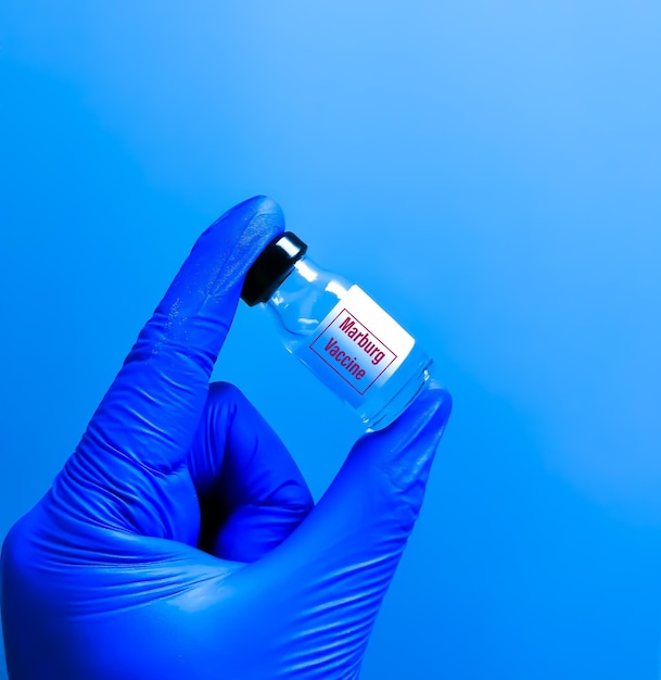 Photo researcher holding vaccine vial of marburg virus and vaccination concept.