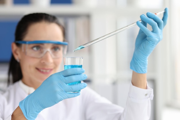 Researcher scientist working with blue liquid test tube in laboratory chemical science or