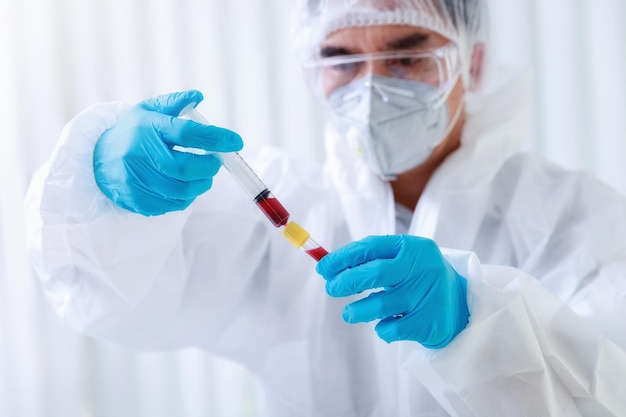研究者または科学者は、血液サンプルを実験室の試験管にロードします.研究者は、COVID19 ウイルスを治療するためのワクチンを発明しています
