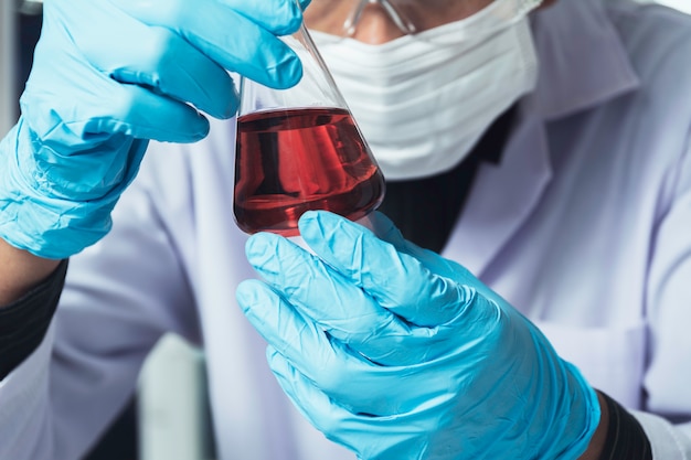 Researcher with glass laboratory chemical test tubes with liquid for analytical, medical