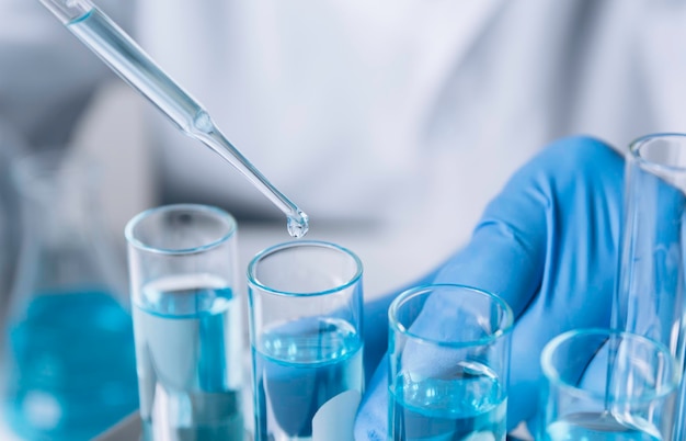 写真 分析医療医薬品および科学研究コンセプトのための液体を含むガラス実験室化学試験管を持つ研究者