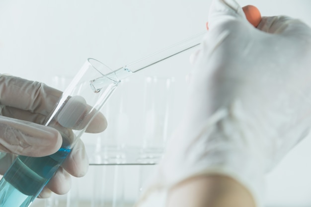 Researcher with glass laboratory chemical test tubes with liquid 