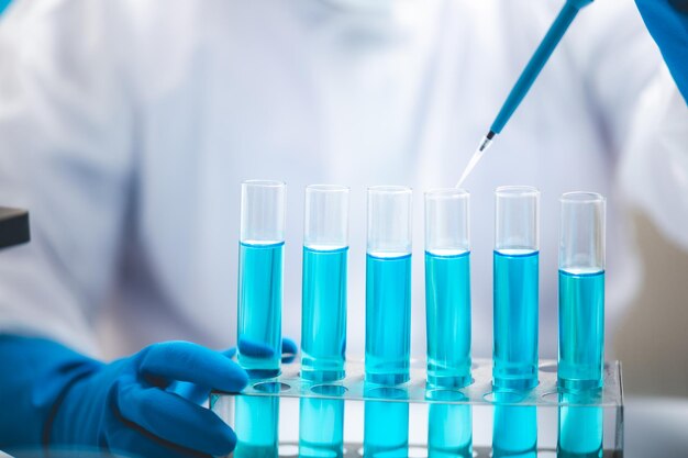 Researchers scientist working analysis with blue liquid test tube in the laboratory chemistry science or medical biology experiment technology pharmacy development solution