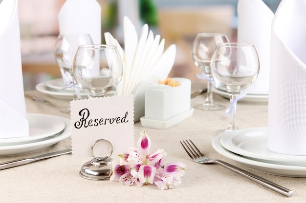 Foto segno riservato sul tavolo del ristorante con piatti vuoti e bicchieri