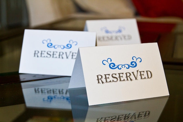 Reserved Signs with Ornate Blue Design on Reflective Glass Surface CloseUp