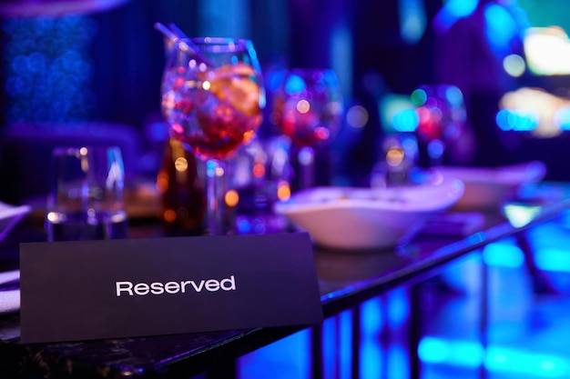 Reserved table in night club against the background of\
multicolored spotlights