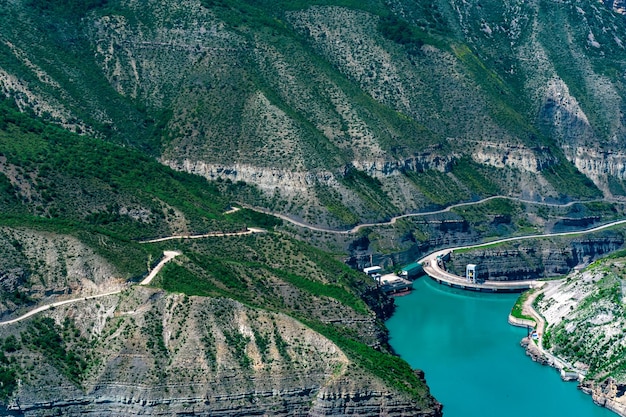 Reservoir in a mountain canyon and the upper part of the arch dam of a hydroelectric power plant