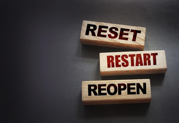 Reset restart reopen on wooden blocks on black Post pandemic world concept